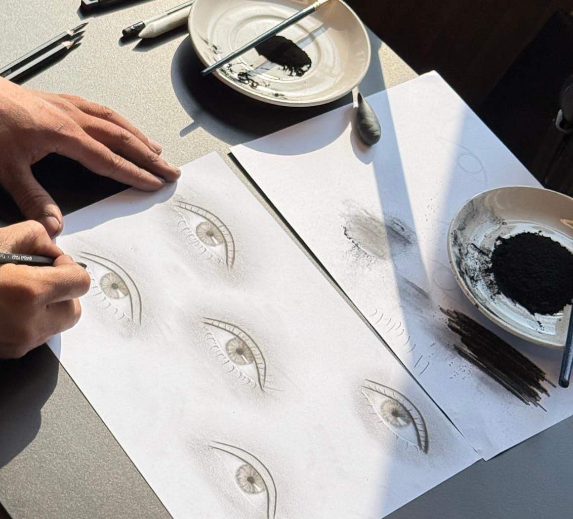Charcoal eye studies and drawing materials during a Science of Sketching one-day technical class