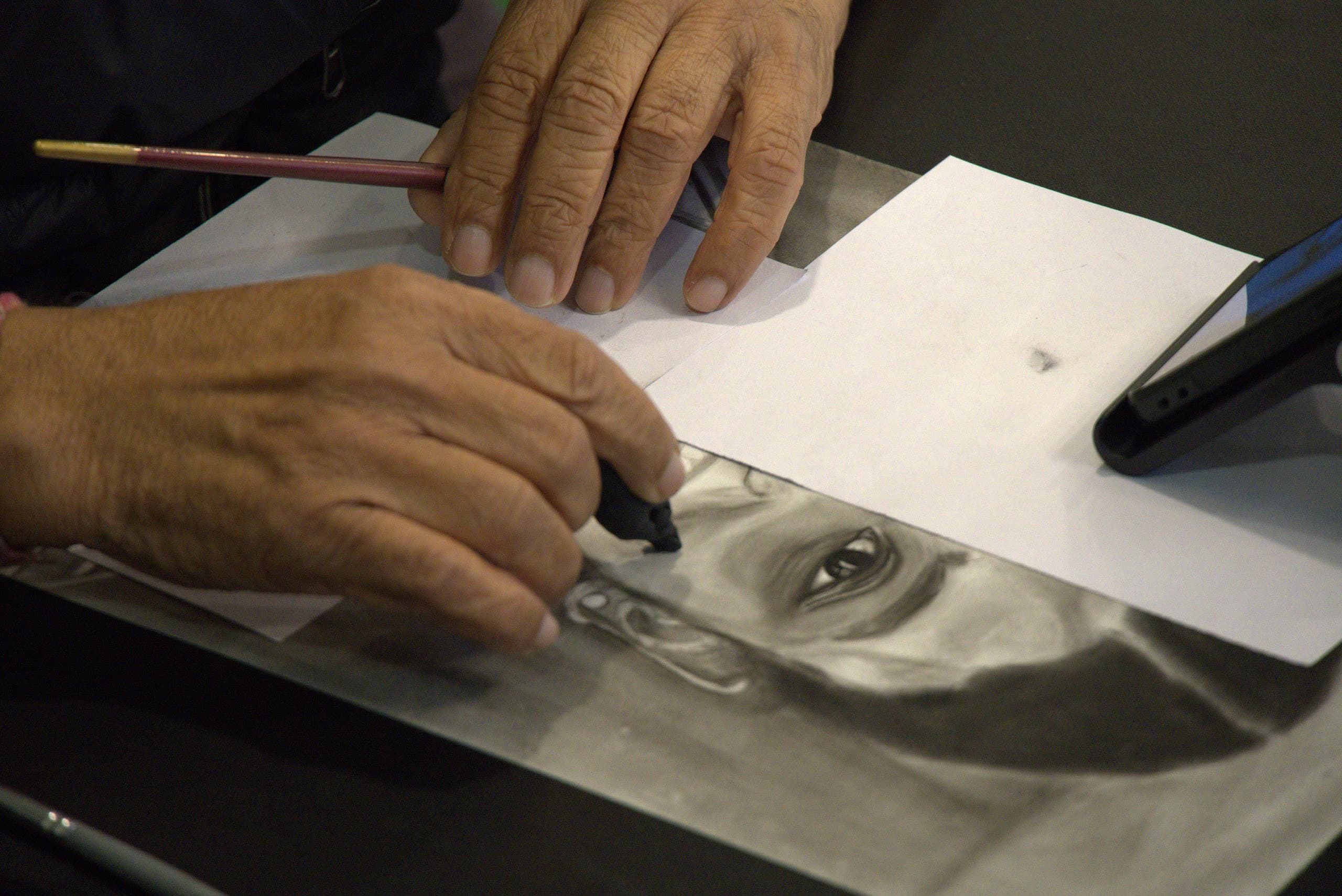 Artist refining a detailed charcoal portrait study