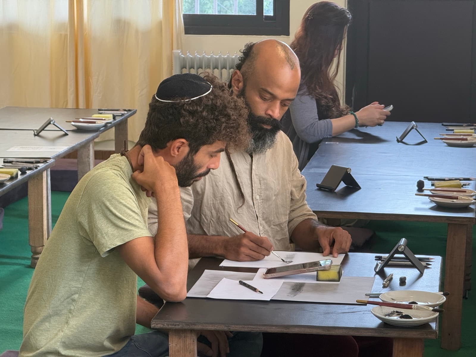Teacher offering focused drawing guidance to students during a Science of Sketching workshop