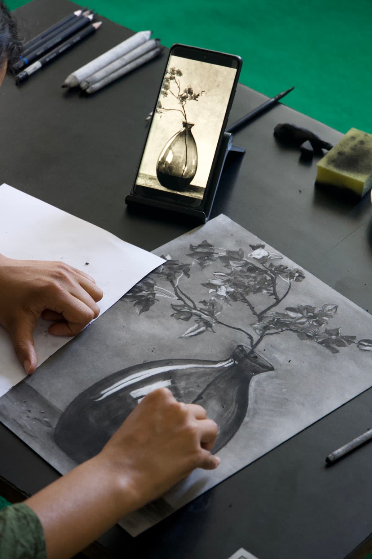 Student drawing a charcoal still life from a vase reference at the Science of Sketching studio